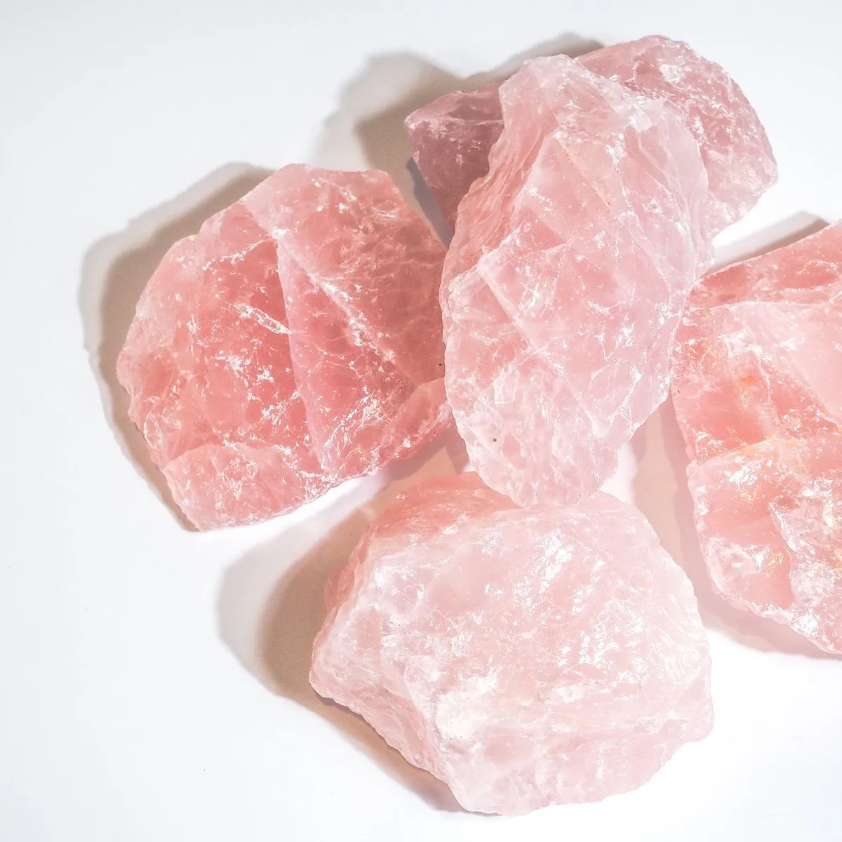 A collection of rose quartz jewelry including rings and bracelets, showcasing the stone's soft pink glow in various styles.