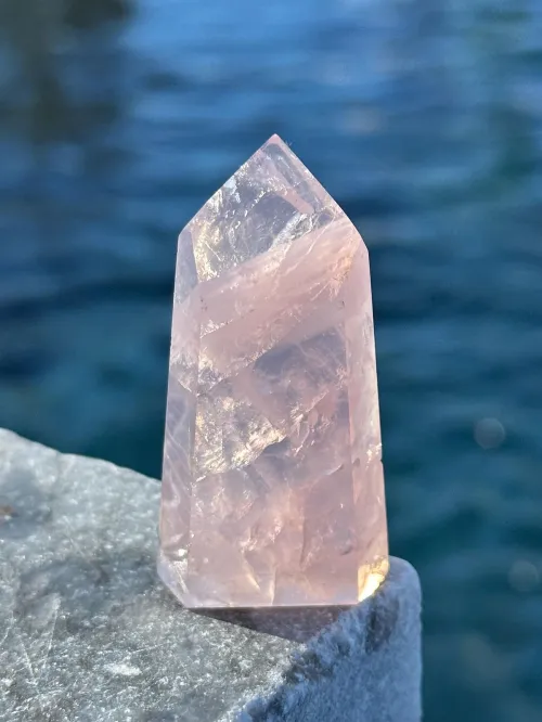 A rose quartz pendant catching light with serene aesthetics
