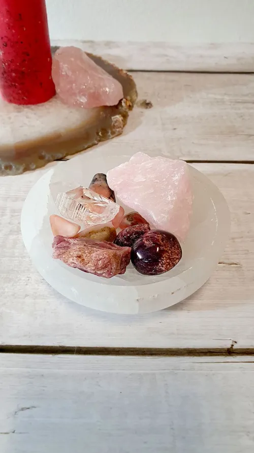 Close-up of rose quartz resting on coarse Himalayan salt crystals