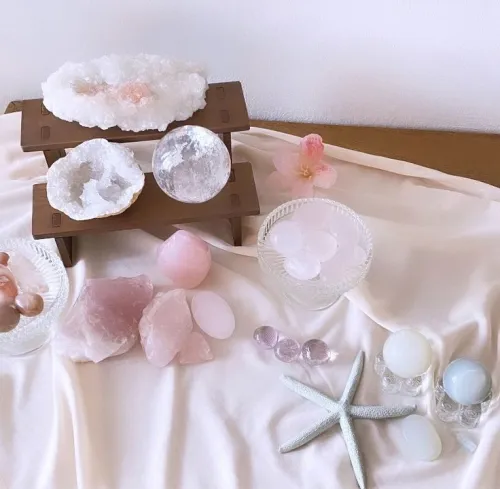 A smooth rose quartz palm stone resting on an open book