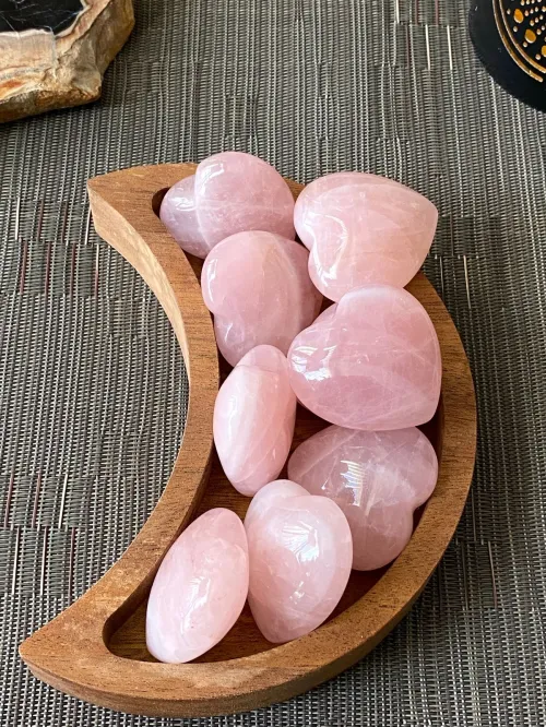 Hand holding rose quartz, overlooking a sunset horizon symbolizing Sagittarius adventure with heart