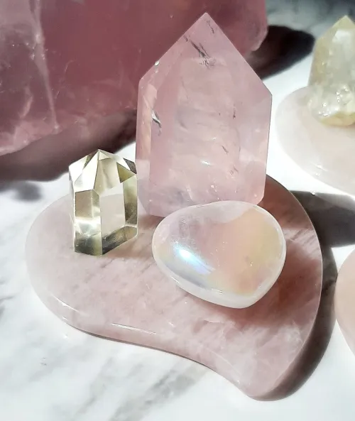 Person holding cleansed rose quartz, sunlight highlighting its enhanced clarity and color