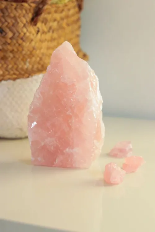 Rose quartz being gently hand-washed under soft water stream