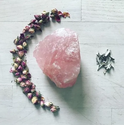 Scattered rose quartz beads on a wooden surface