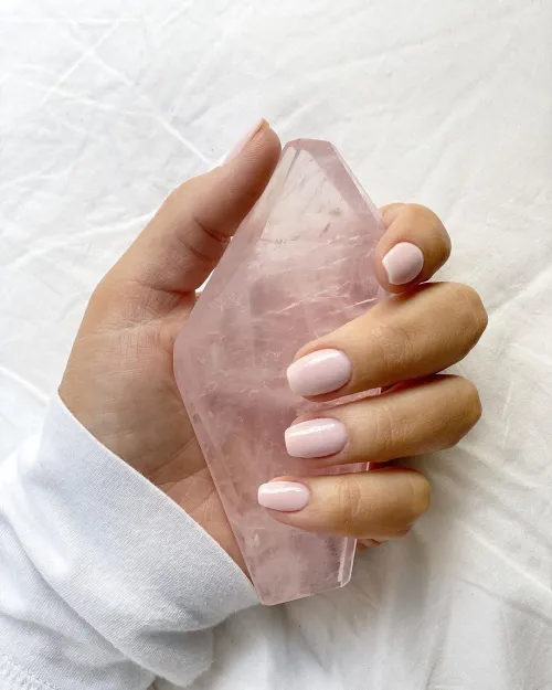 Smooth tumbled rose quartz stones in hand during meditation